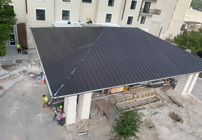 Metal roofing installation team working on a commercial building in Monmouth